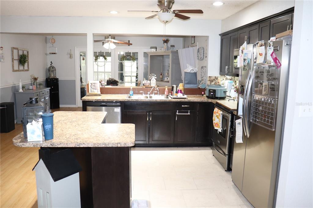 12387 Seagate Street Spring Hill, FL 34609 - Photo 3 of 51 a kitchen with stainless steel appliances granite countertop a refrigerator a stove and a sink