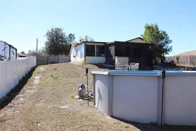a view of a kitchen with a sink and dishwasher a barbeque with potted plants