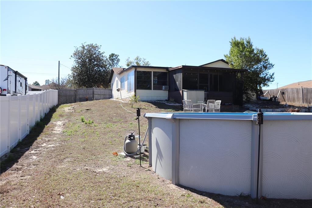 12387 Seagate Street Spring Hill, FL 34609 - Photo 37 of 51 a view of backyard with seating space and trees in the background