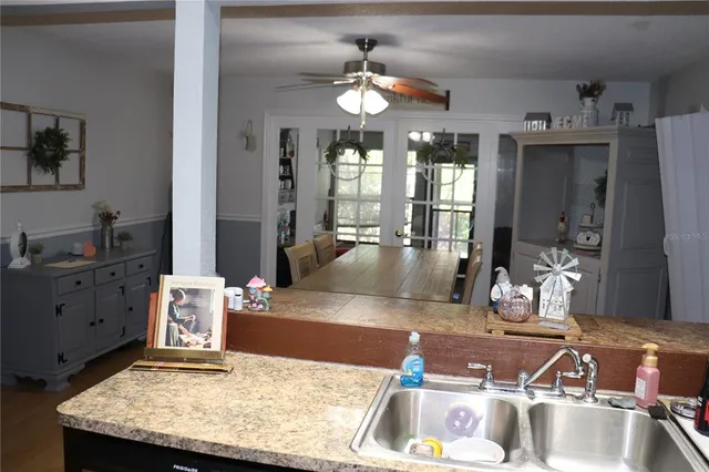 a room with kitchen island granite countertop a sink dishwasher stove and cabinets