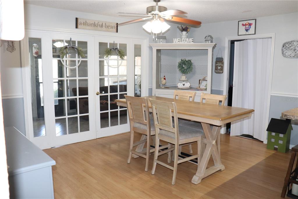 12387 Seagate Street Spring Hill, FL 34609 - Photo 6 of 51 a dining room with wooden floor a chandelier a wooden table and chairs