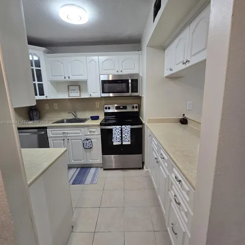 a kitchen with stainless steel appliances granite countertop a stove top oven a sink and dishwasher