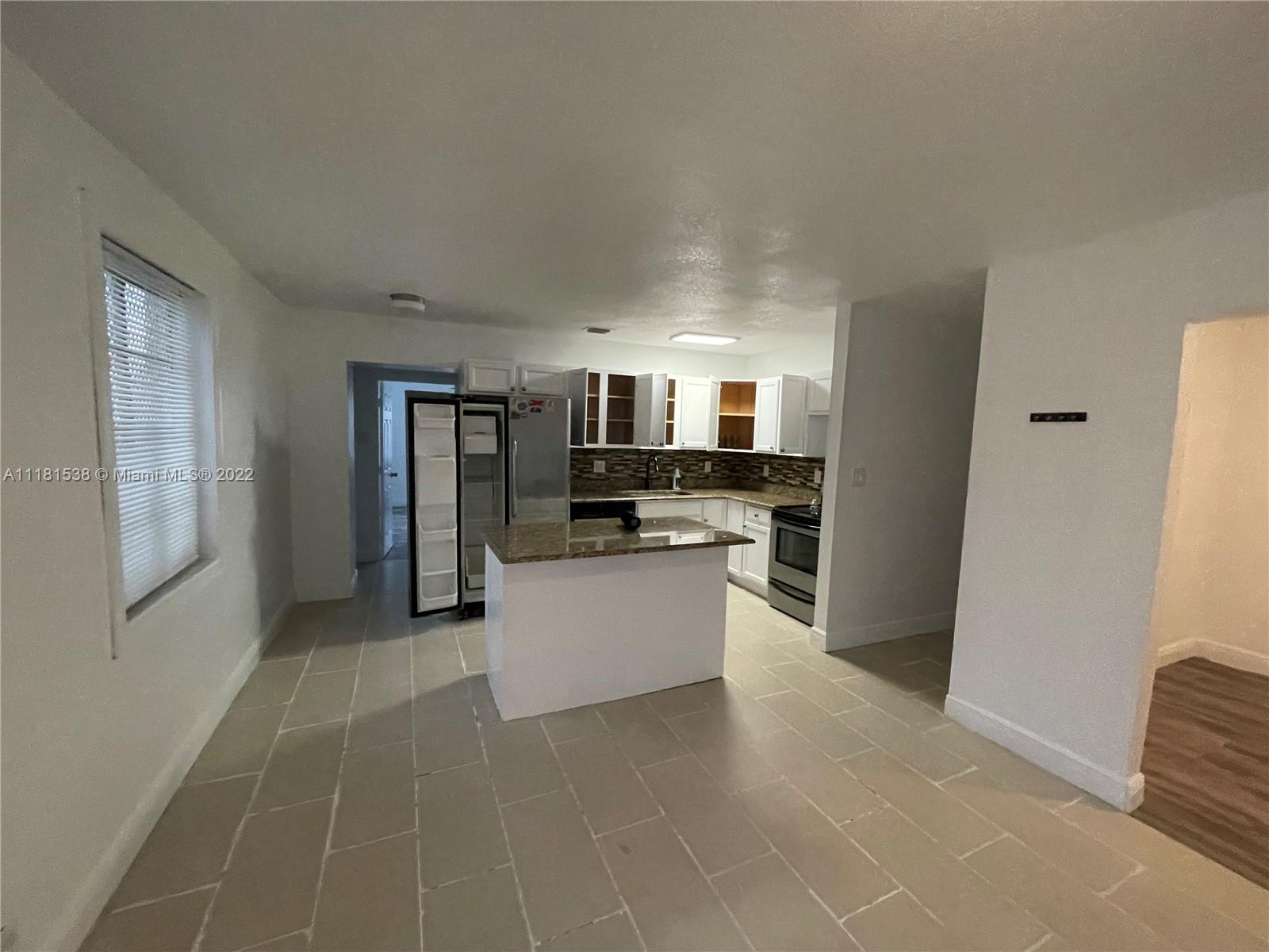 832 West 4th Street Riviera Beach, FL 33404 - Photo 6 of 21 a large white kitchen with refrigerator stove and sink