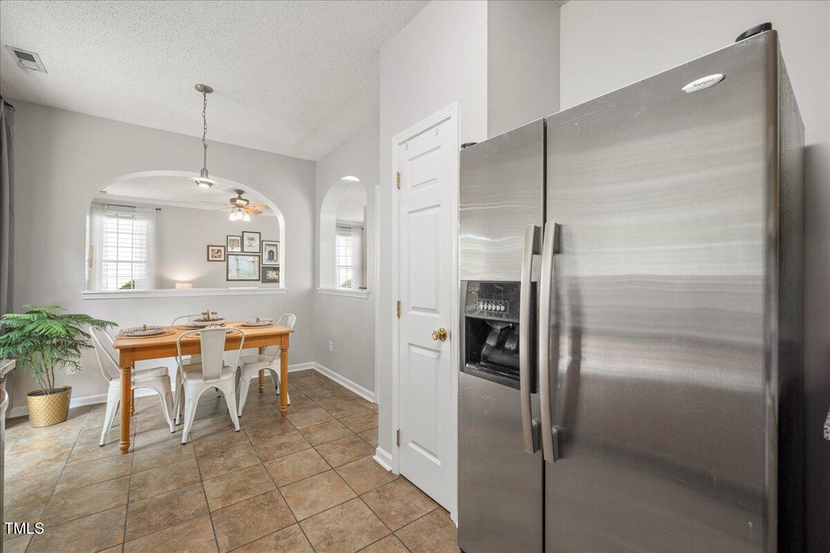 4524 Drewbridge Way Raleigh, NC 27604 - Photo 11 of 29 a kitchen with refrigerator and table chair