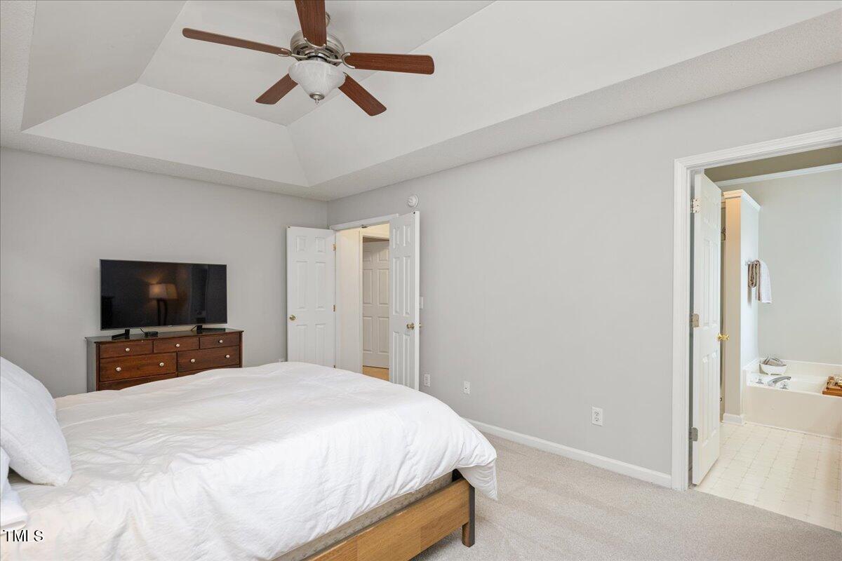 4524 Drewbridge Way Raleigh, NC 27604 - Photo 15 of 29 a bedroom with a bed and a flat tv screen on dresser