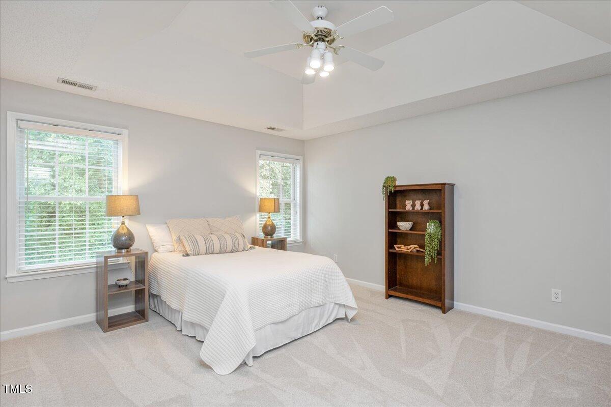 4524 Drewbridge Way Raleigh, NC 27604 - Photo 18 of 29 a bedroom with a bed and a chandelier