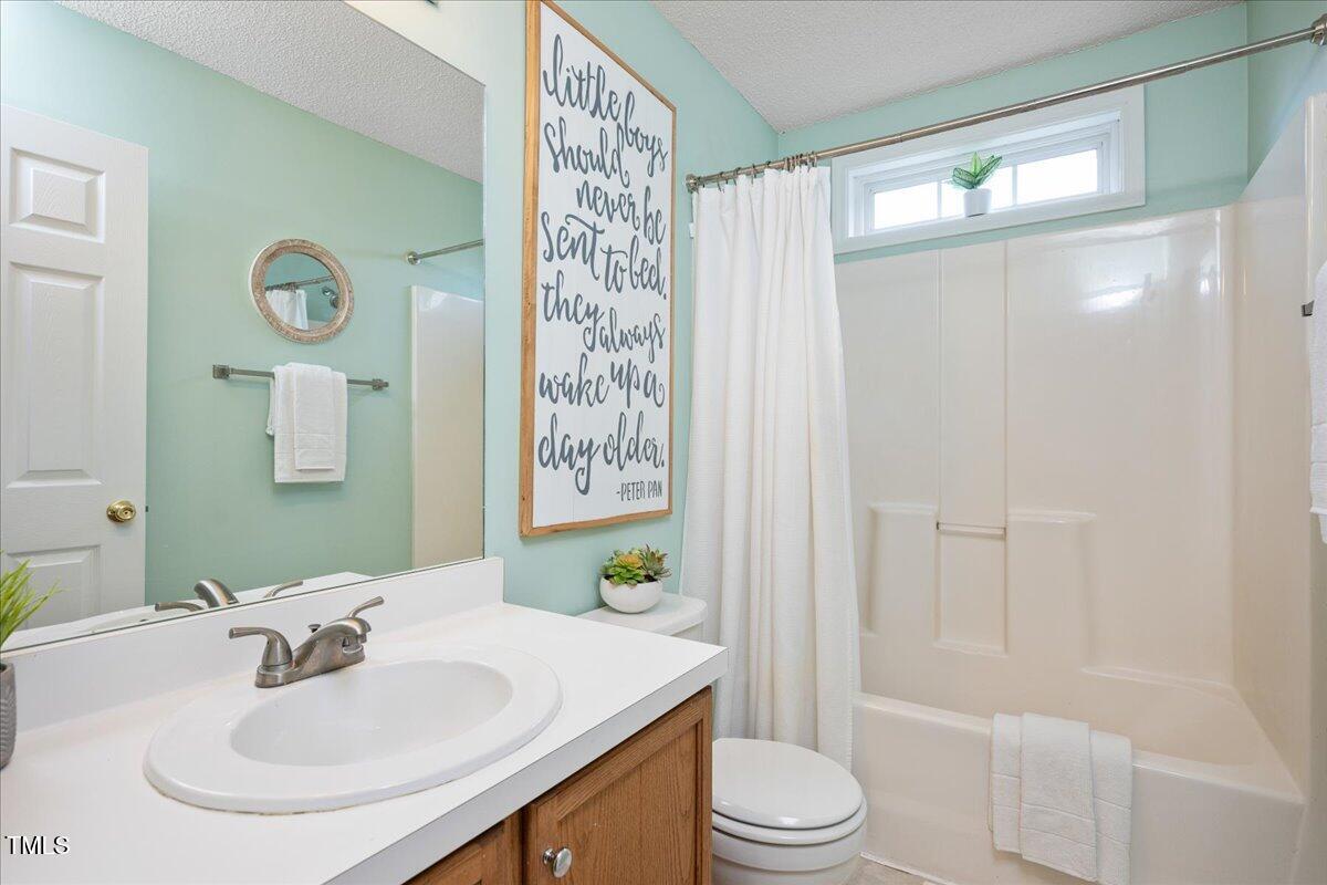 4524 Drewbridge Way Raleigh, NC 27604 - Photo 20 of 29 a bathroom with a sink toilet a mirror and shower