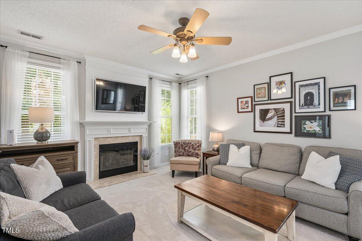 4524 Drewbridge Way Raleigh, NC 27604 - Photo 6 of 29 a living room with furniture a fireplace and a flat screen tv