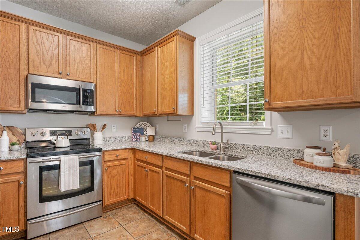 4524 Drewbridge Way Raleigh, NC 27604 - Photo 8 of 29 a kitchen with granite countertop a sink stainless steel appliances and cabinets