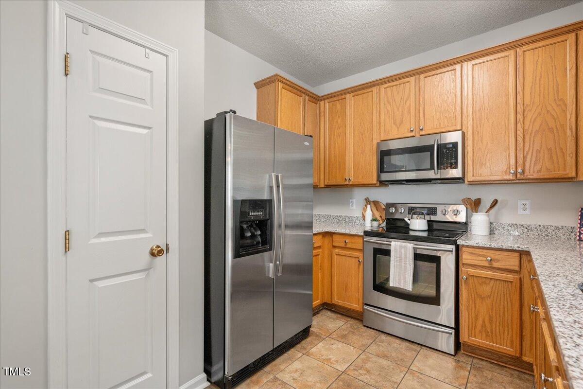 4524 Drewbridge Way Raleigh, NC 27604 - Photo 9 of 29 a kitchen with stainless steel appliances granite countertop a refrigerator stove and microwave