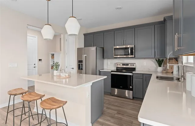 a kitchen with kitchen island stainless steel appliances a sink and white cabinets