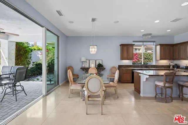 a open dining room with kitchen island furniture a rug a large window and chairs