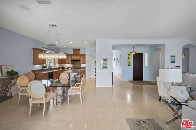 a dining room with furniture a chandelier and wooden floor