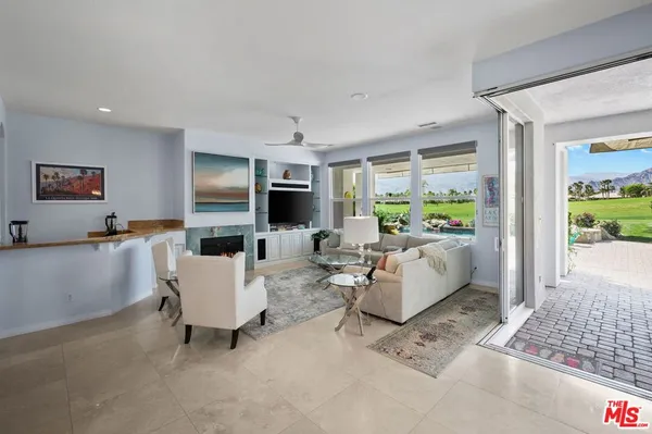 a living room with furniture flat screen tv and a large window