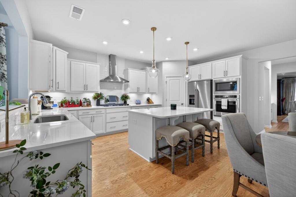 7277 Maple Brook Lane Flowery Branch, GA 30542 - Photo 21 of 93 a kitchen with stainless steel appliances granite countertop a refrigerator and microwave