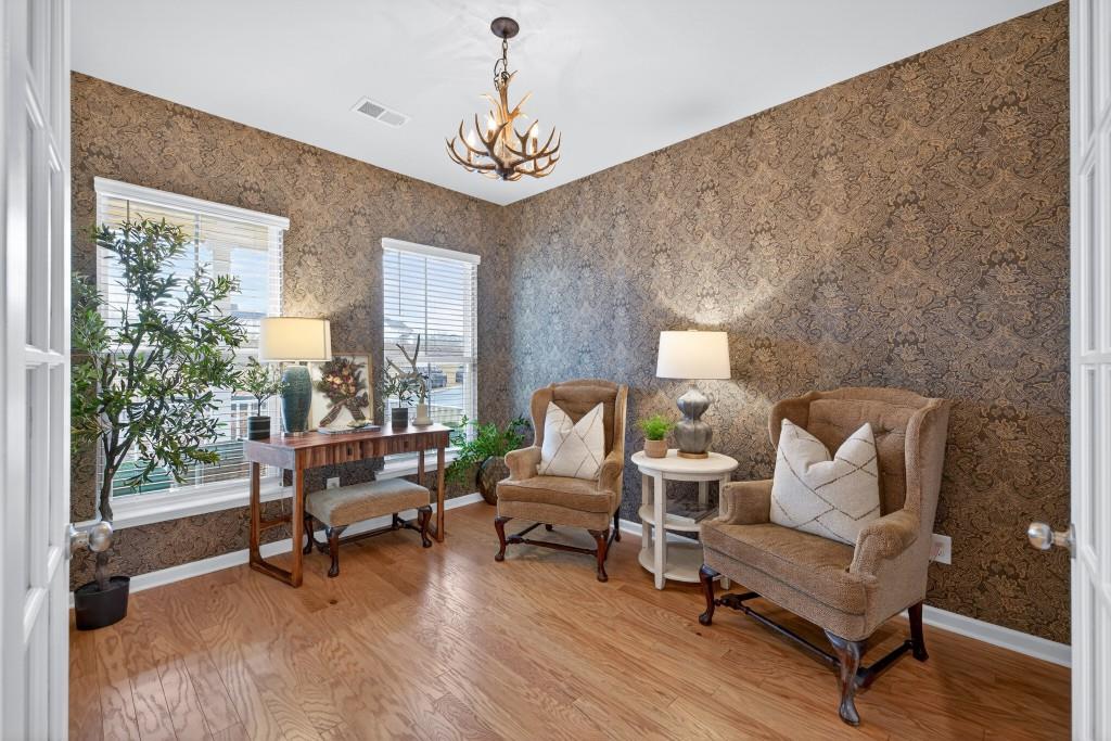 7277 Maple Brook Lane Flowery Branch, GA 30542 - Photo 41 of 93 a living room with furniture and a chandelier