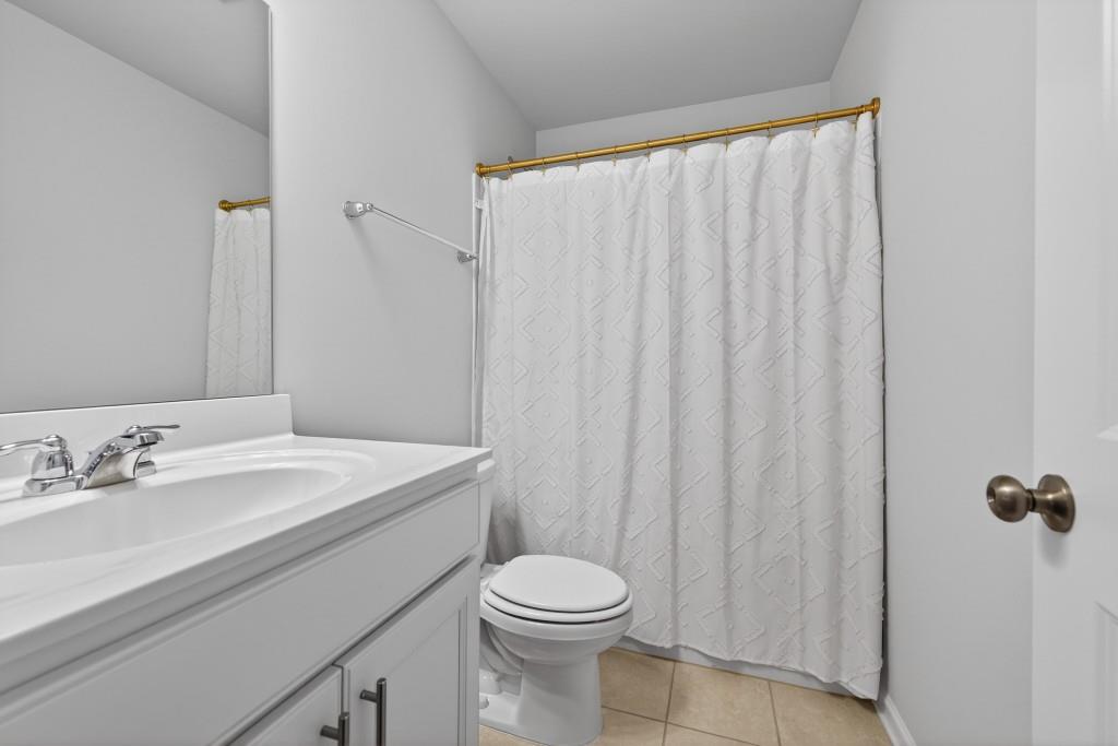 7277 Maple Brook Lane Flowery Branch, GA 30542 - Photo 50 of 93 a bathroom with a sink a toilet and shower curtain