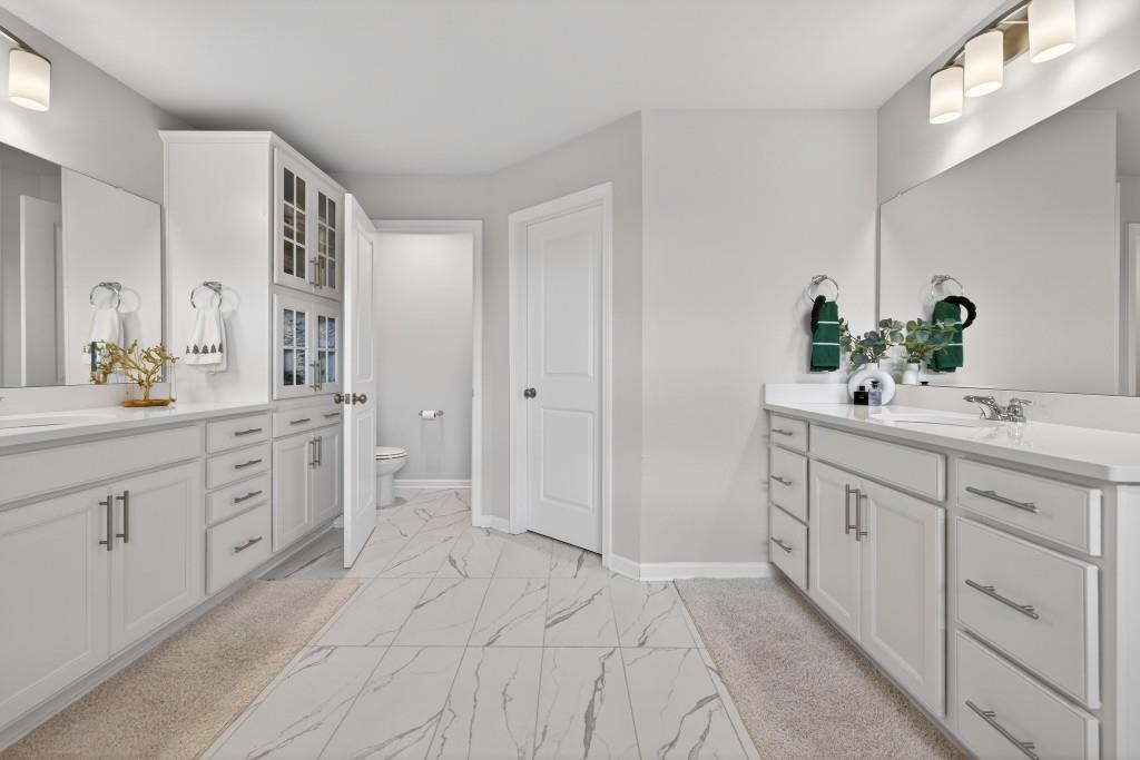 7277 Maple Brook Lane Flowery Branch, GA 30542 - Photo 67 of 93 a spacious bathroom with a double vanity sink a large mirror a bathtub and