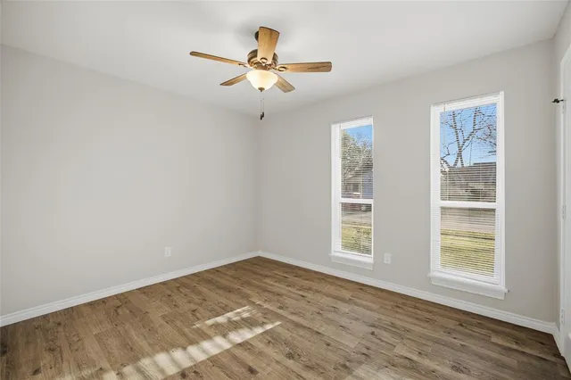 a view of a bedroom with wooden floor and a window