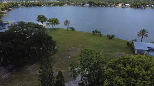 an aerial view of a house with a yard and lake view