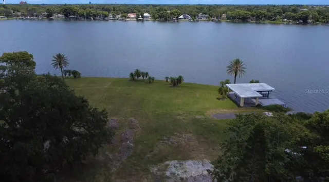 a backyard of a house with lots of green space and lake view