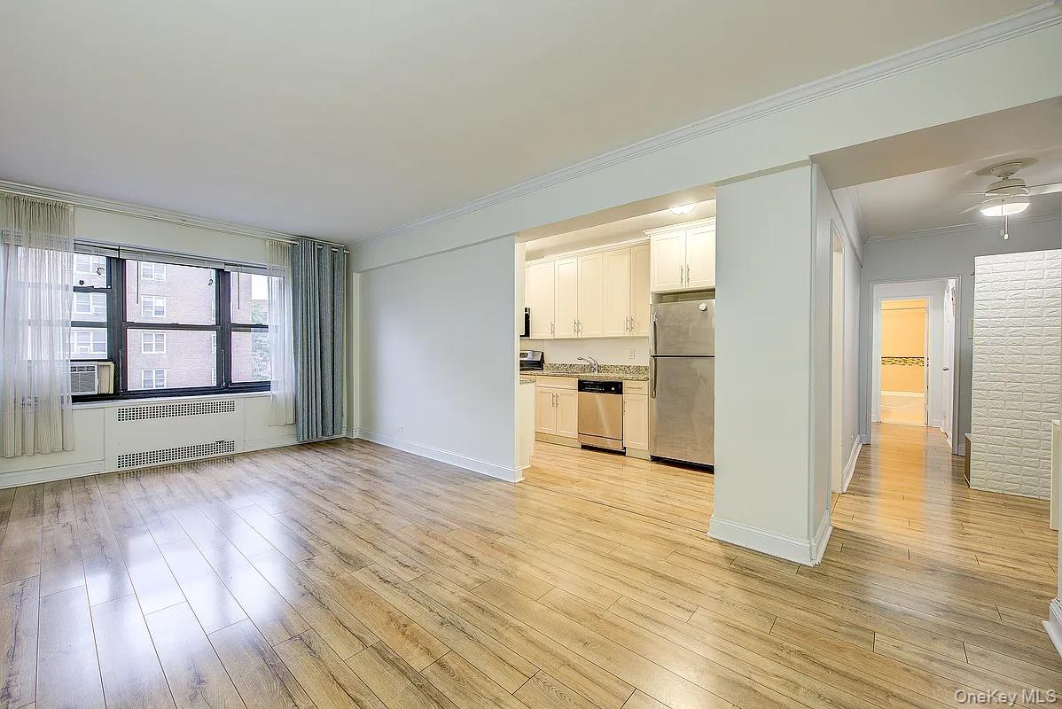 a view of empty room with wooden floor and windows