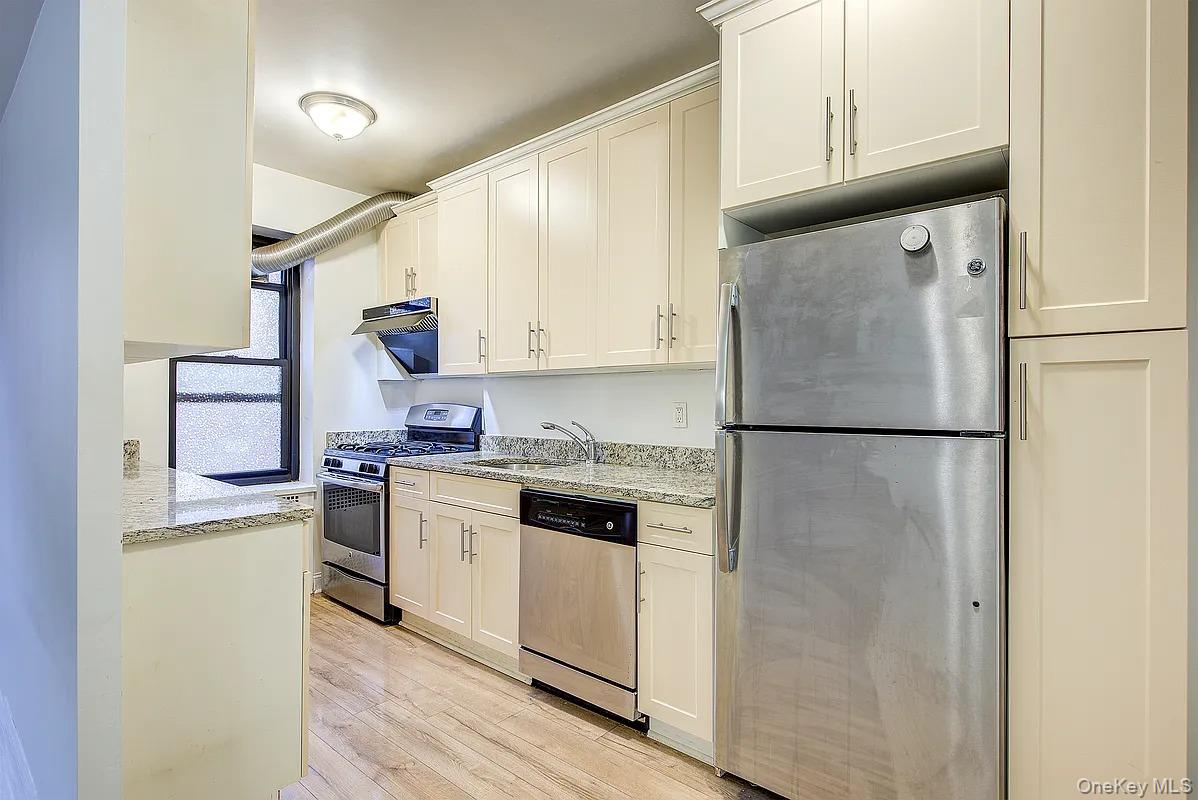 67-76 Booth Street, Unit 4F Queens, NY 11375 - Photo 11 of 33 a kitchen with a refrigerator sink and cabinets