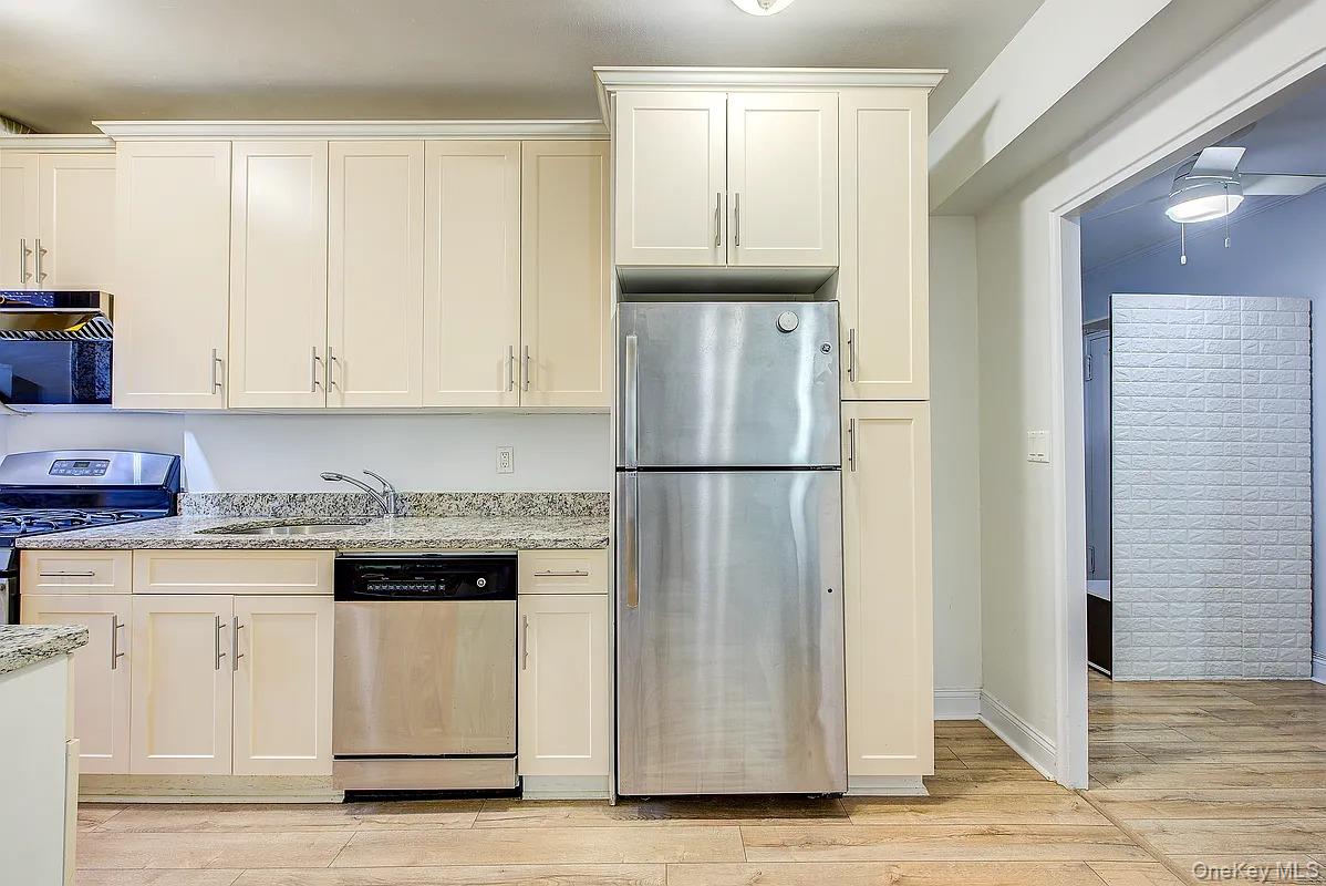 67-76 Booth Street, Unit 4F Queens, NY 11375 - Photo 12 of 33 a kitchen with stainless steel appliances granite countertop a refrigerator sink and cabinets