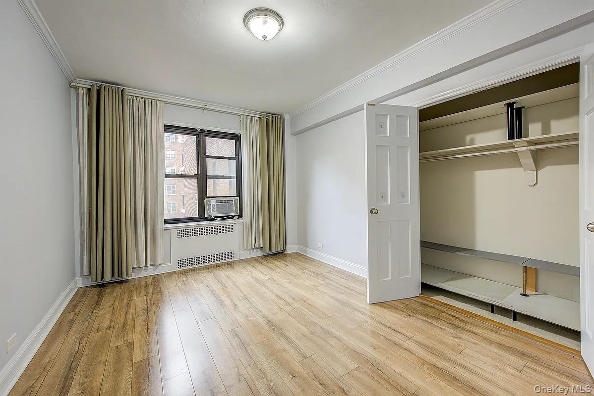 67-76 Booth Street, Unit 4F Queens, NY 11375 - Photo 24 of 33 an empty room with wooden floor door and windows