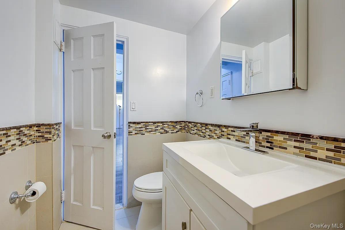 67-76 Booth Street, Unit 4F Queens, NY 11375 - Photo 25 of 33 a bathroom with a sink a toilet a shower and a mirror