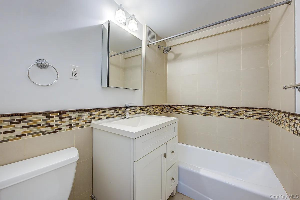 67-76 Booth Street, Unit 4F Queens, NY 11375 - Photo 26 of 33 a bathroom with a sink a toilet and a bathtub