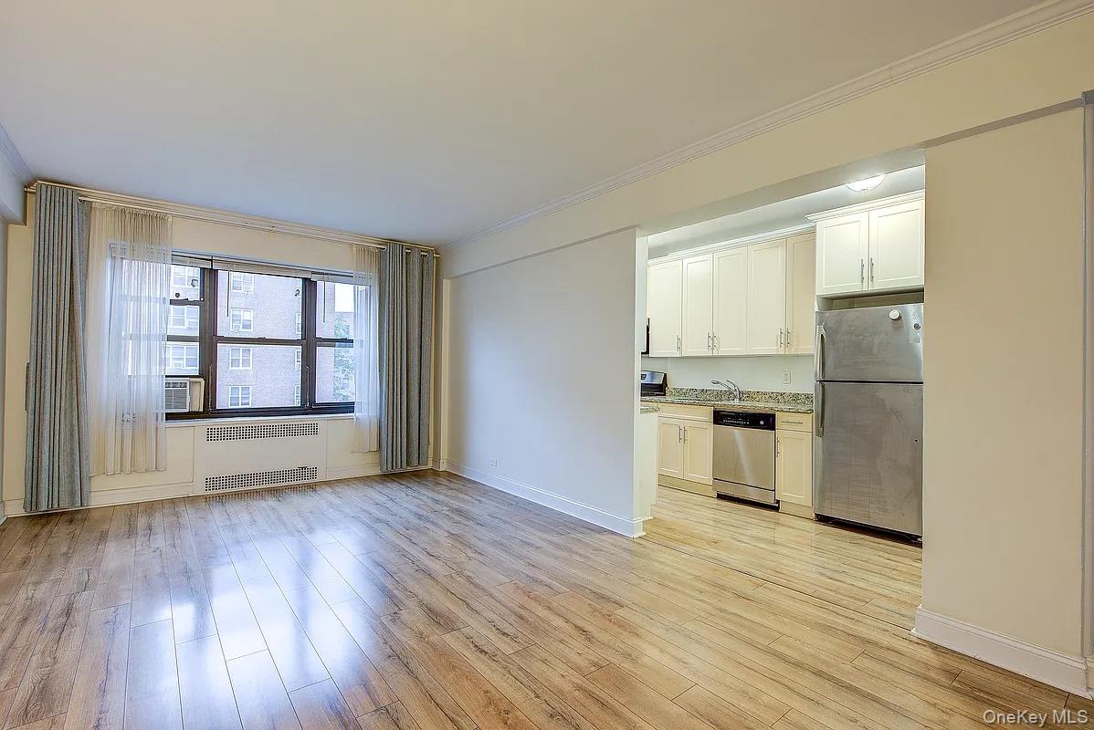 67-76 Booth Street, Unit 4F Queens, NY 11375 - Photo 9 of 33 a view of an empty room with a window and wooden floor