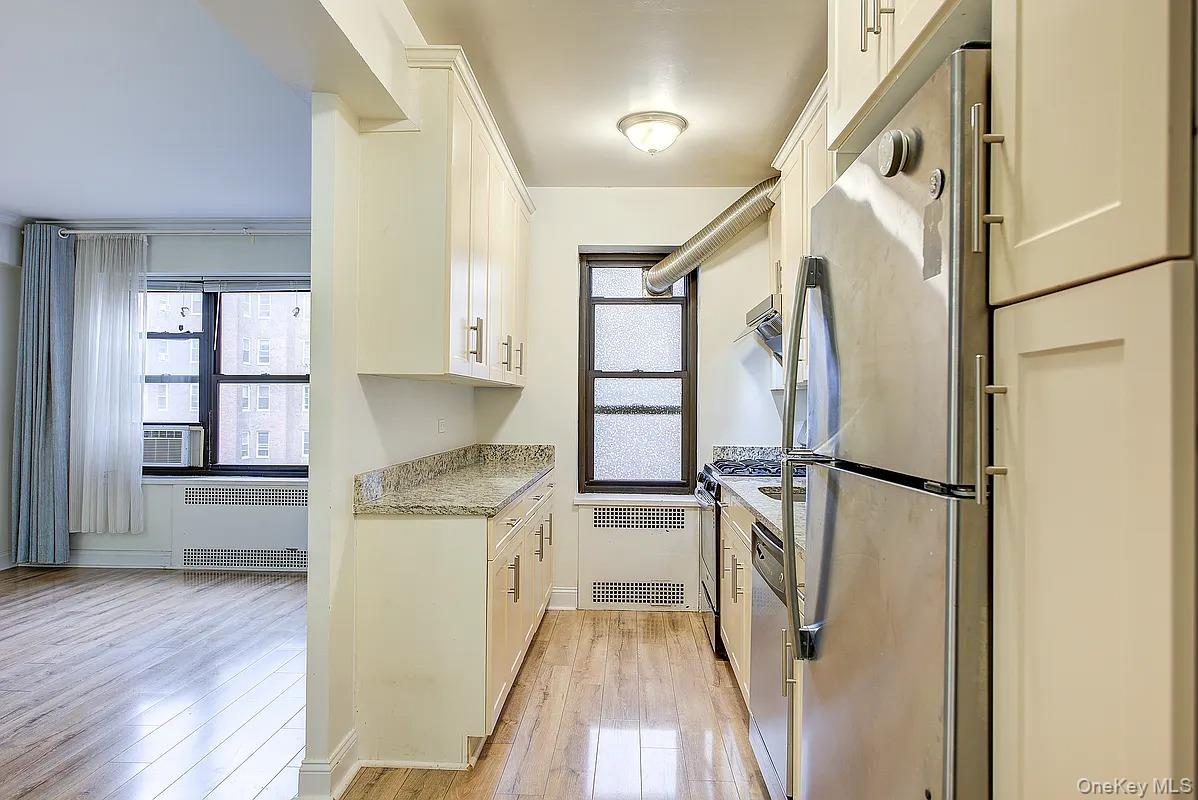 67-76 Booth Street, Unit 4F Queens, NY 11375 - Photo 10 of 33 a kitchen with a refrigerator a sink and wooden floor