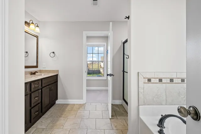 a bathroom with a double vanity sink a mirror and a shower