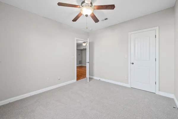 an empty room with chandelier fan