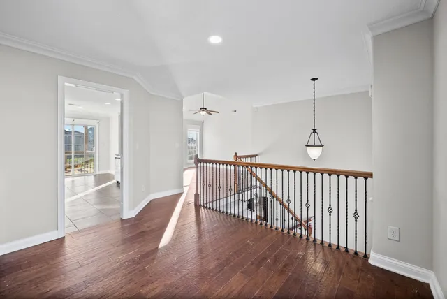 a view of a hallway with wooden floor and a chandelier