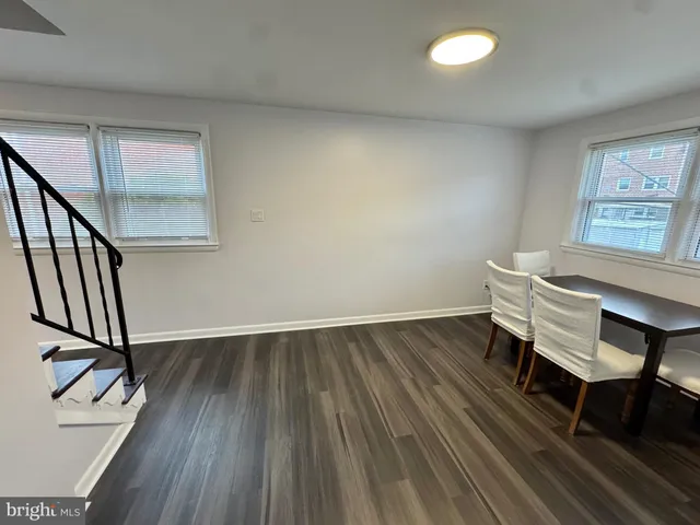 a view of a room with wooden floor and a hallway