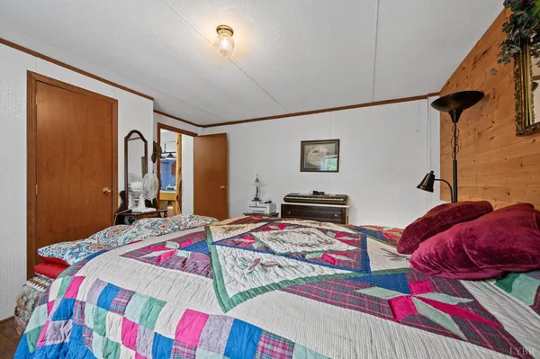 a bedroom with a bed and dresser with rug