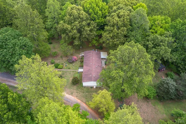 an aerial view of residential house with outdoor space and trees all around