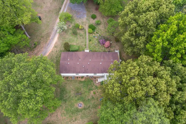 an aerial view of residential house with outdoor space and trees all around