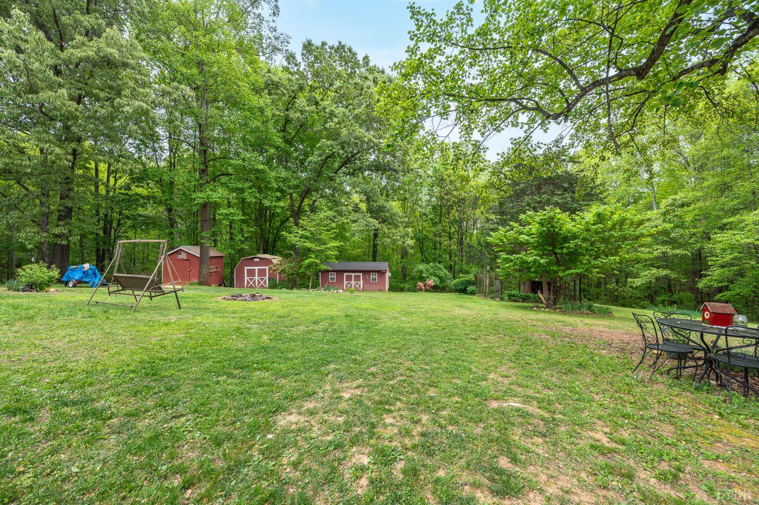 142 Micklem Lane Shipman, VA 22971 - Photo 33 of 38 a backyard of a house with childrens swings and slides