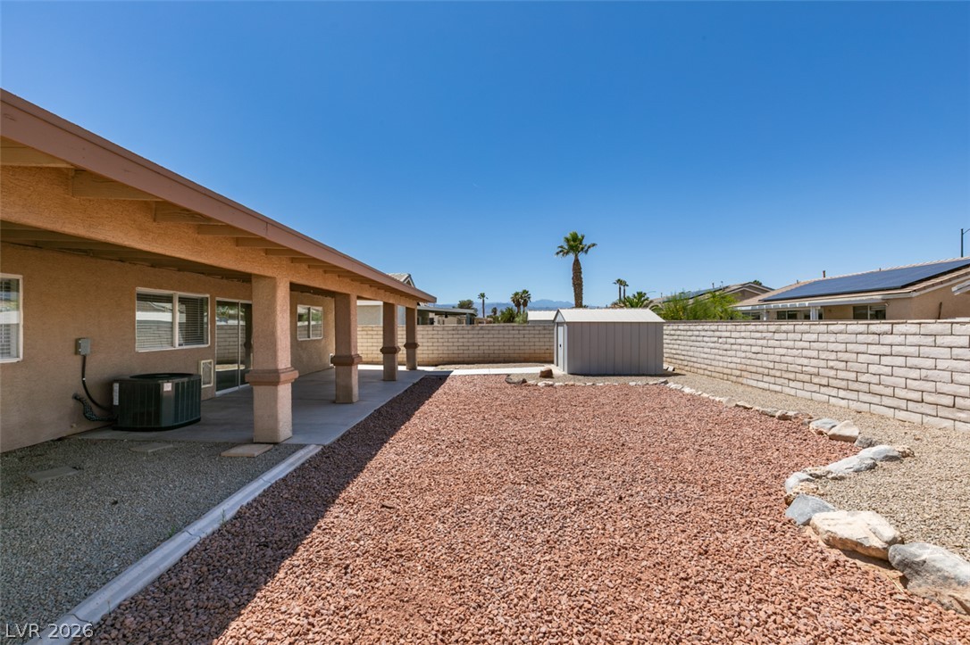 2028 Rustler Ridge Avenue North Las Vegas, NV 89031 - Photo 37 of 40 A spacious backyard features a covered patio, shed, and gravel landscaping.