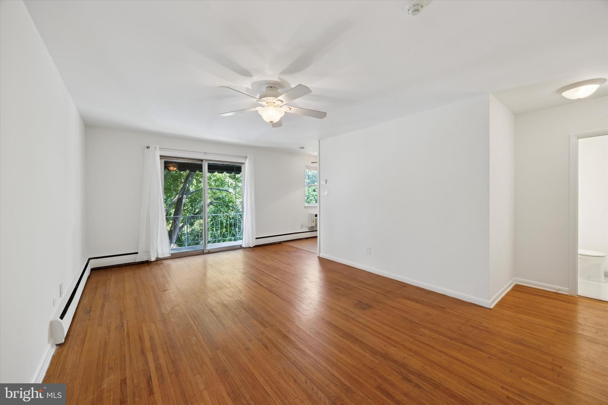 1600 Church Road, Unit A306 Wyncote, PA 19095 - Photo 4 of 15 a view of an empty room with wooden floor and a window