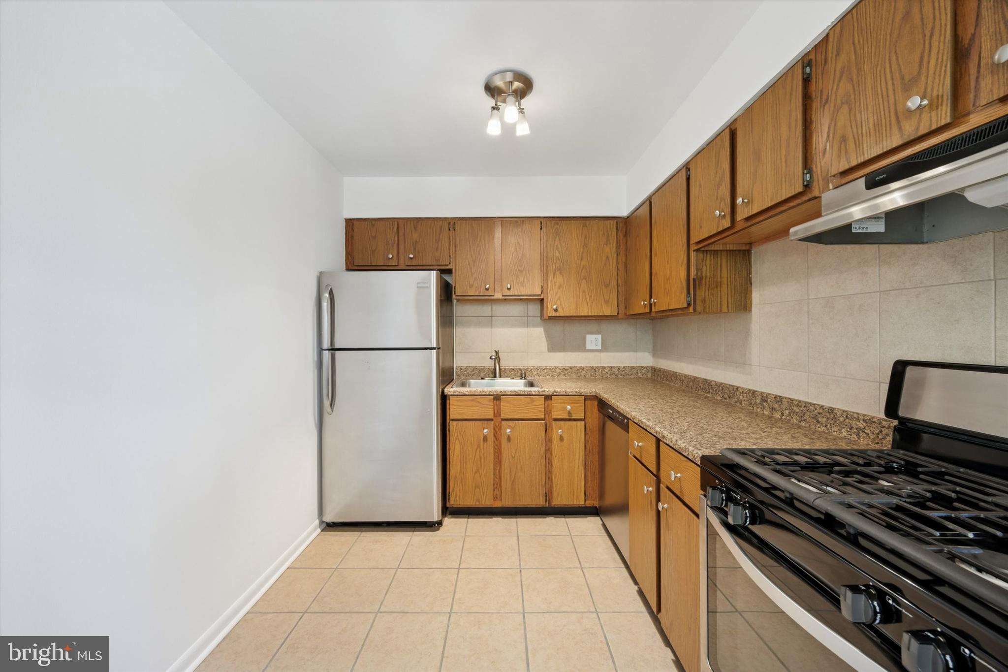 1600 Church Road, Unit A306 Wyncote, PA 19095 - Photo 7 of 15 a kitchen with a stove a refrigerator and cabinets