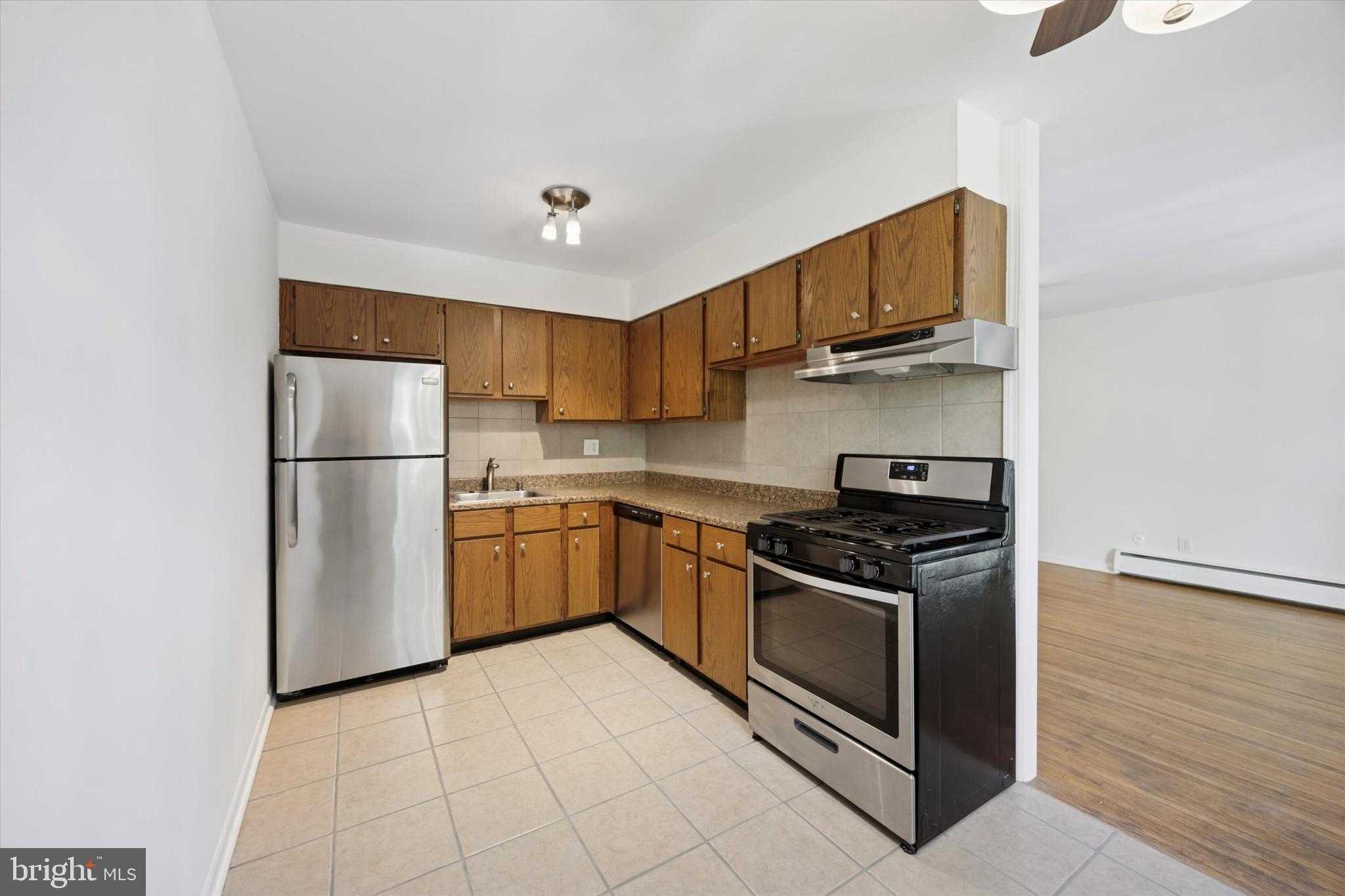 1600 Church Road, Unit A306 Wyncote, PA 19095 - Photo 8 of 15 a kitchen with stainless steel appliances granite countertop a stove a refrigerator and a microwave