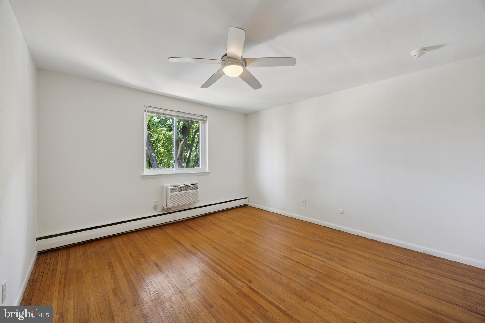 1600 Church Road, Unit A306 Wyncote, PA 19095 - Photo 9 of 15 an empty room with wooden floor chandelier fan and windows
