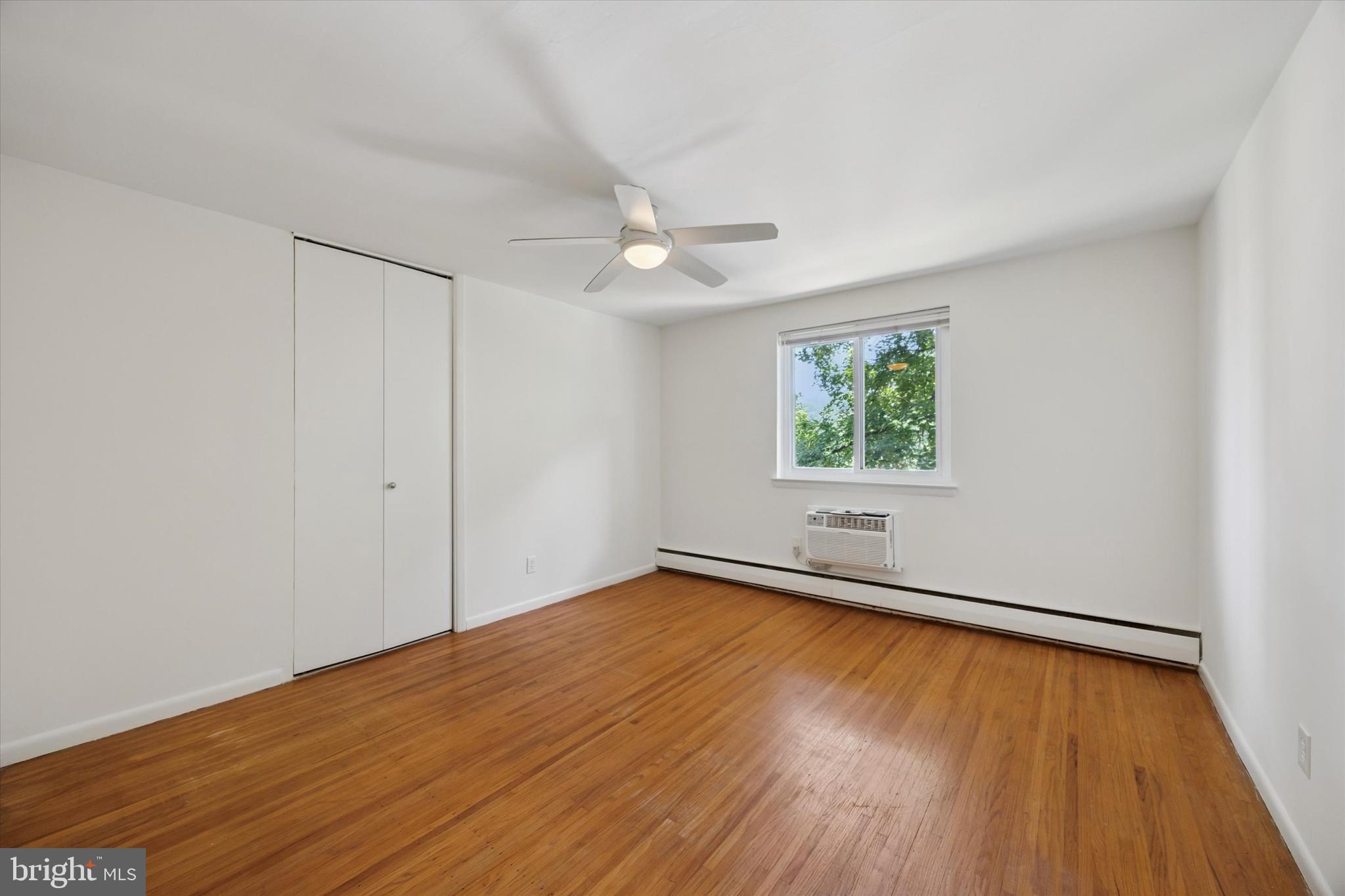 1600 Church Road, Unit A306 Wyncote, PA 19095 - Photo 10 of 15 an empty room with wooden floor chandelier fan and windows