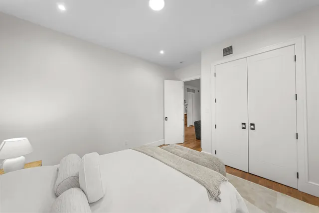 a bedroom with a bed and a painting on the wall