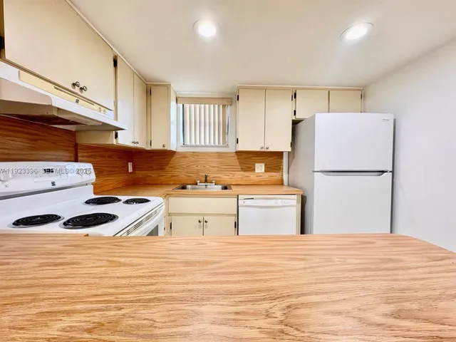 a kitchen with a refrigerator and a stove top oven