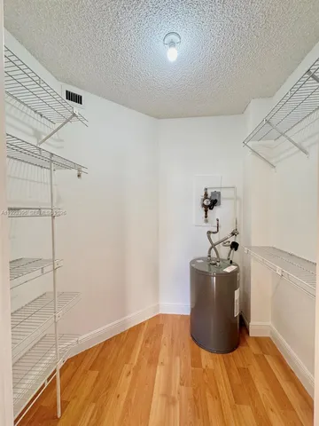 a view of a room with wooden floor and cabinet